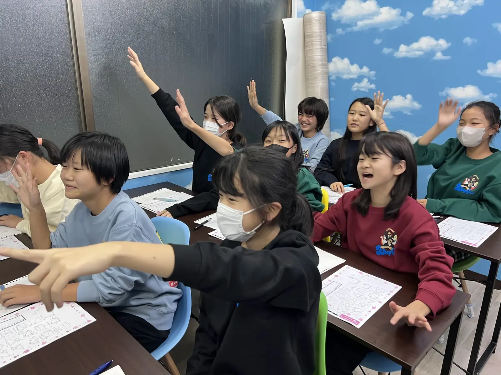 解けた問題に笑顔で手を挙げる生徒たち